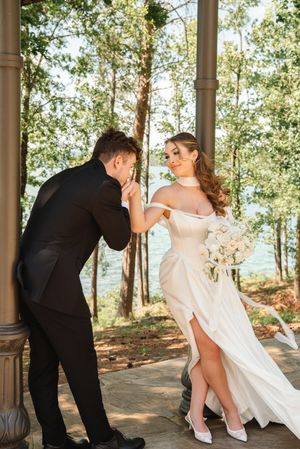 Elegant wedding scene in a woodland gazebo with lake views in background.