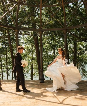 A couple dancing in a gazebo surrounded by trees during their wedding celebration.