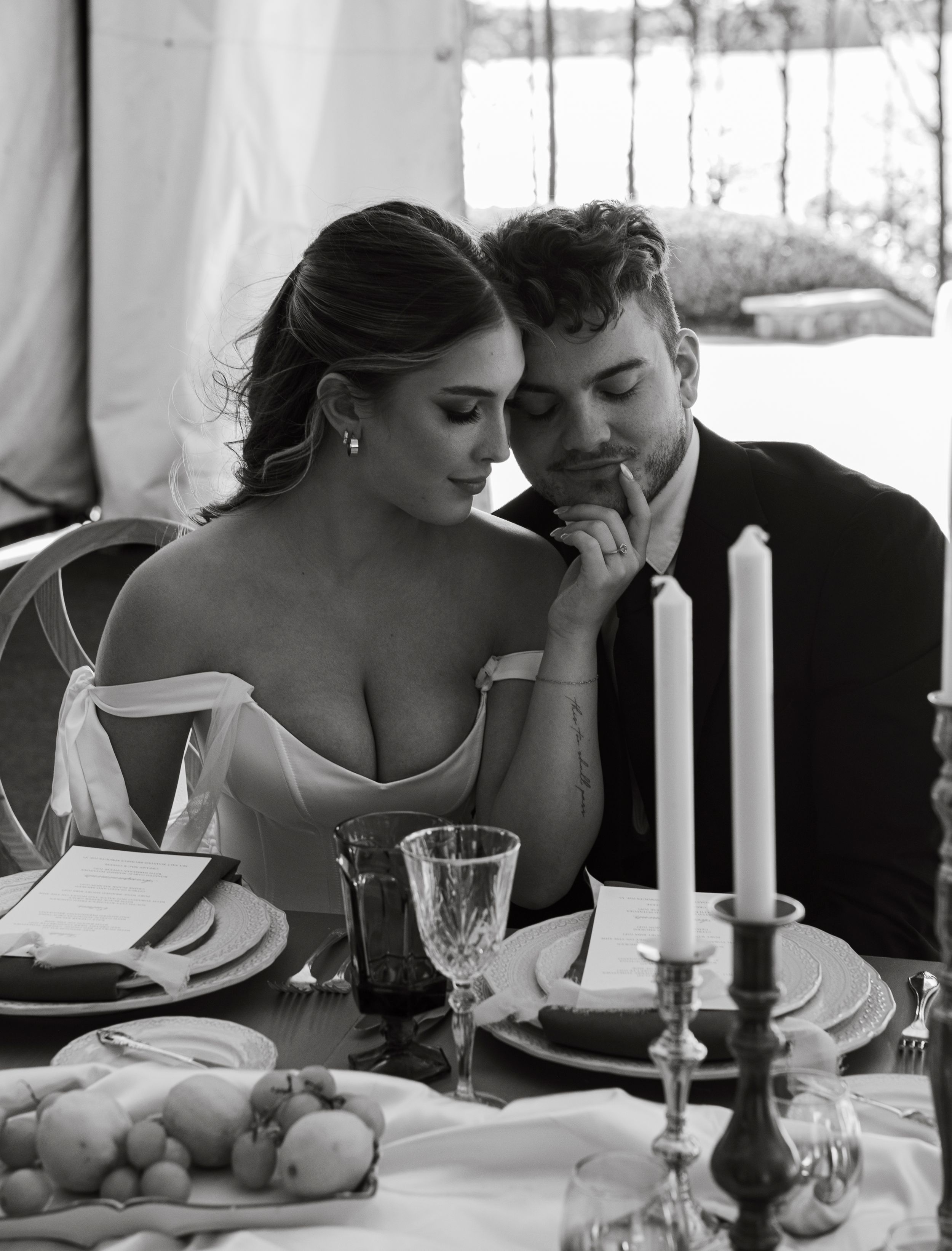 A romantic candlelit dinner setting with an elegant table arrangement featuring candles and formal place settings.