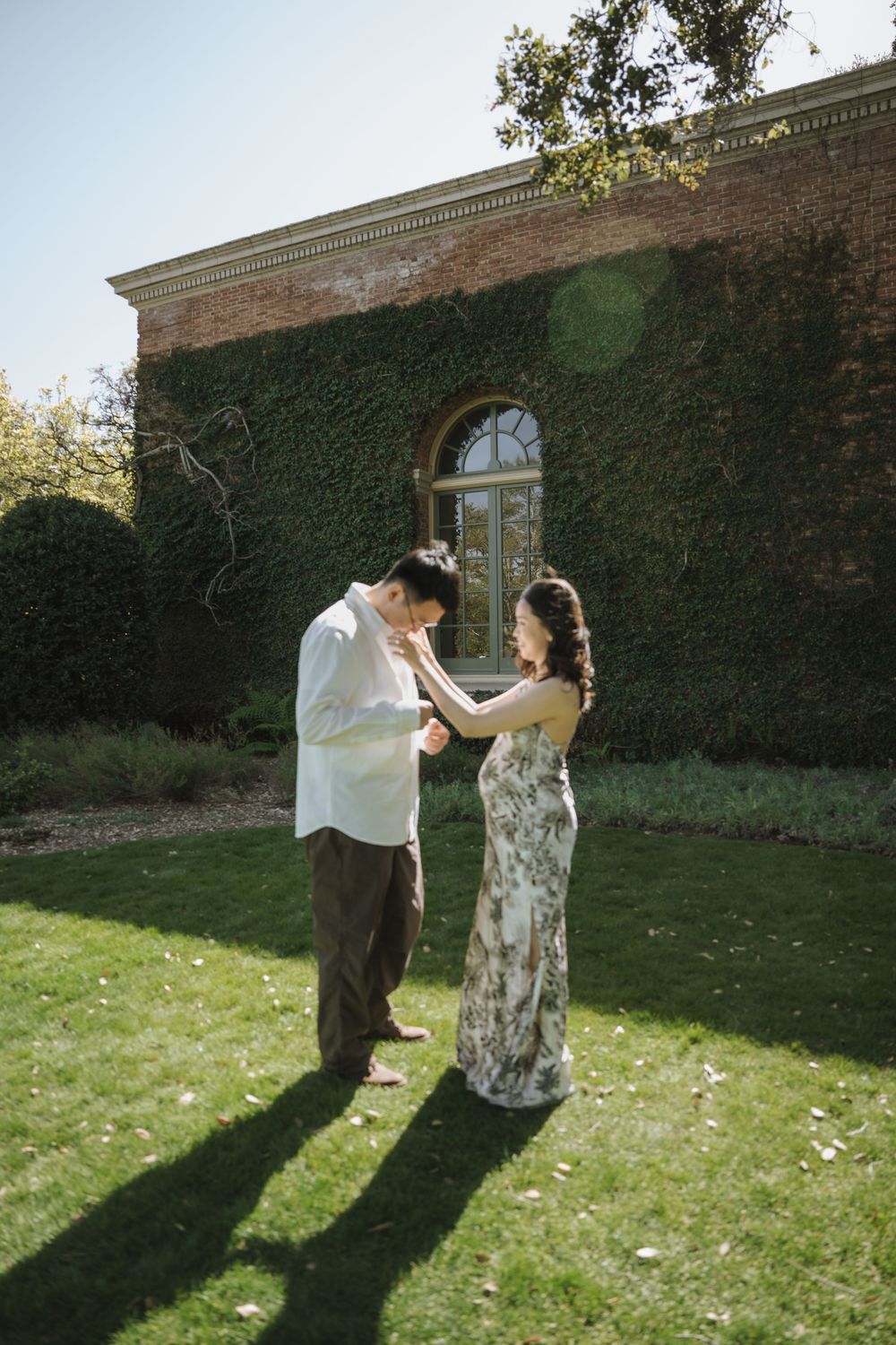 Dancing in a sunny garden with ivy-covered walls creating a romantic backdrop.