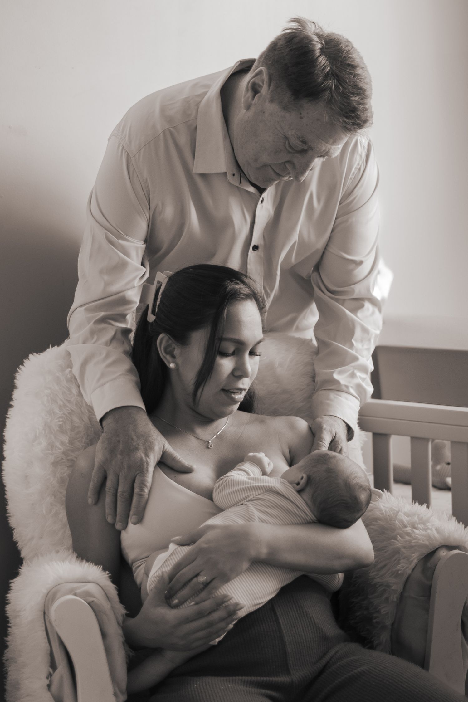 Series of intimate black and white photos showing tender moments between parent and infant.