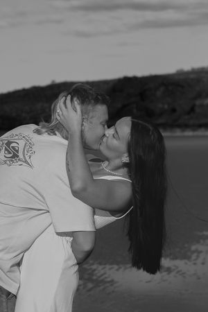 Person in white shirt leans back dramatically in artistic black and white photograph.