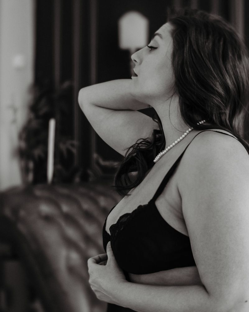 Intimate boudoir portrait in black and white with dramatic lighting.
