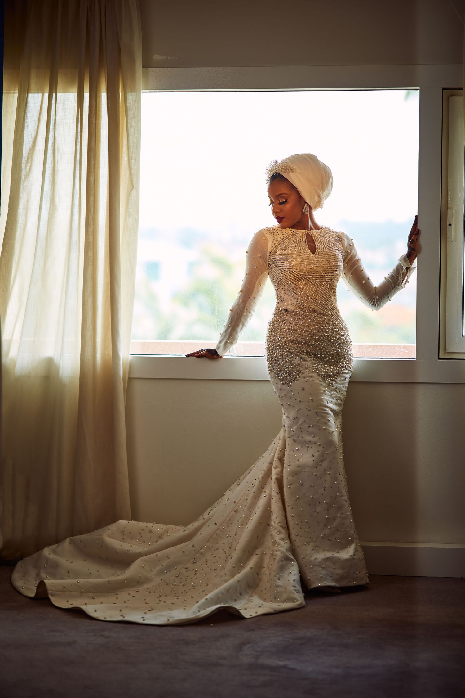 Sequence showing movement of someone in a flowing white wedding dress posing by a window.