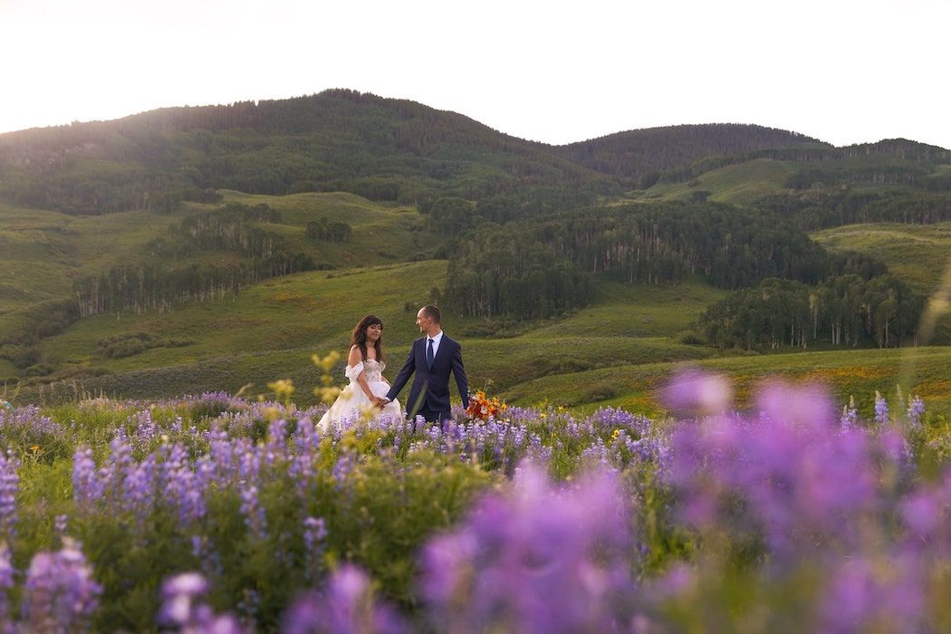 romantic couple on a grass with Mountain View backdrop in colorado