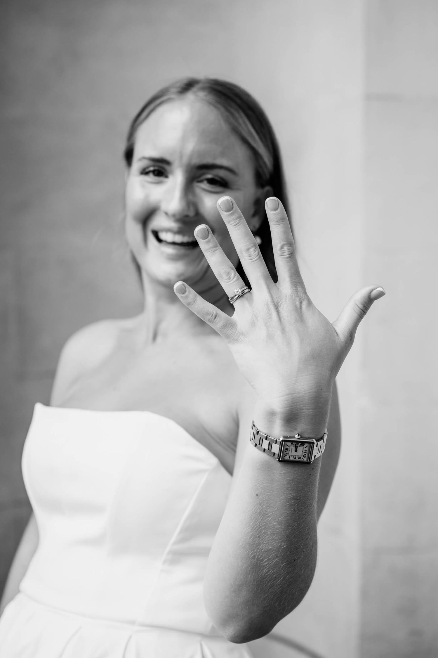 Black and white photo series showing a bride in white dress displaying her engagement ring with joyful expressions.