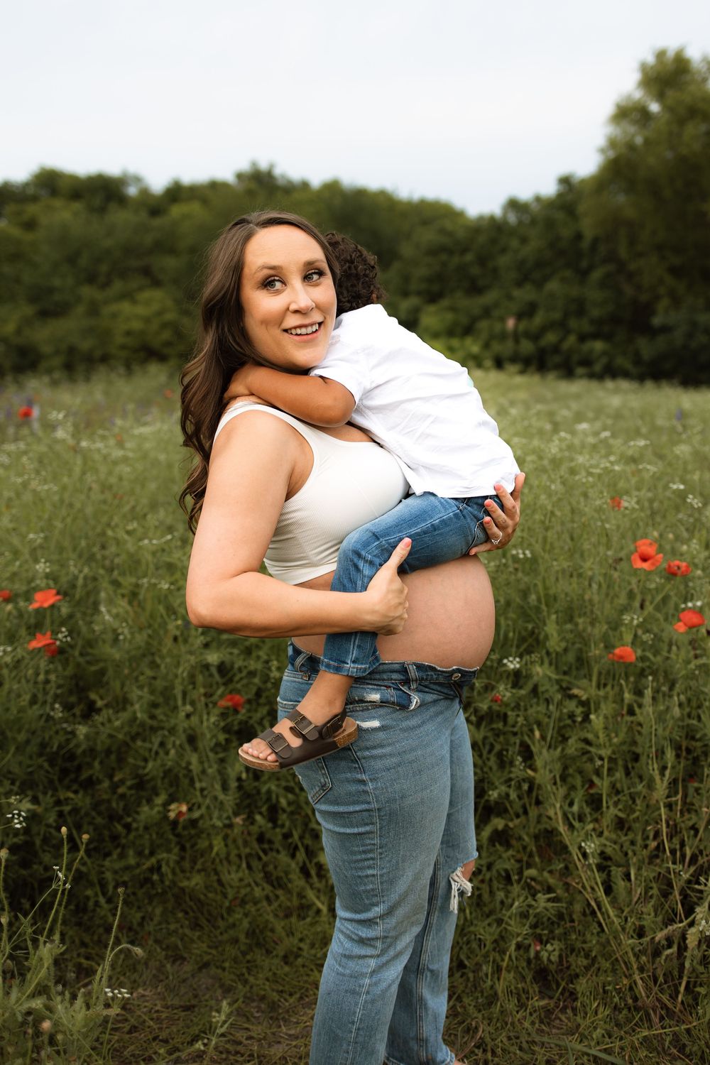 A joyful moment captured in a wildflower meadow with red poppies on a summer afternoon.