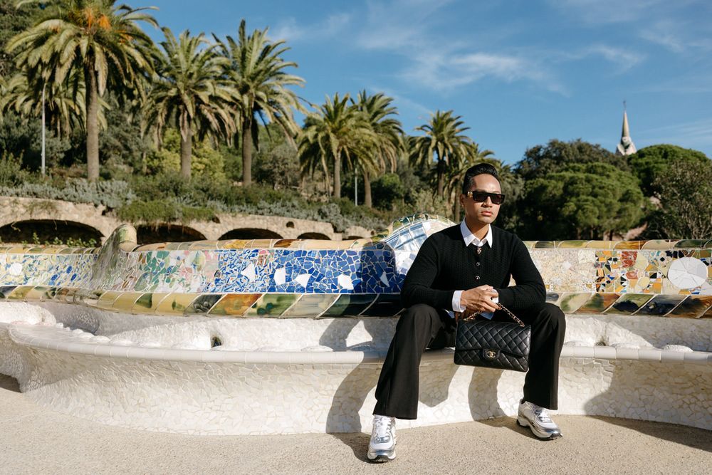 Palm trees line a decorative mosaic wall in Park Guell.