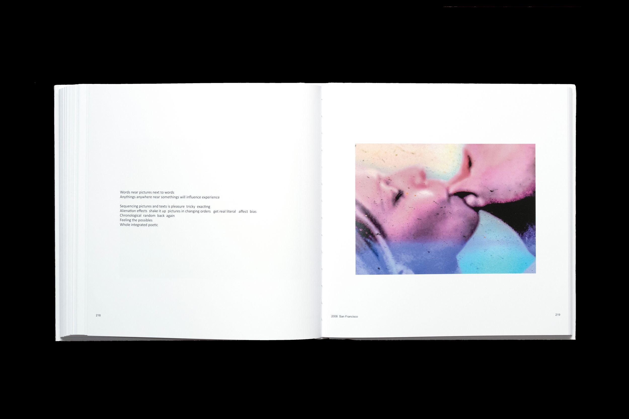An open book displaying soft pink and blue tinted photographs alongside white pages with text.