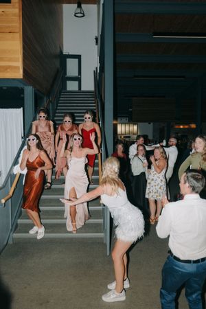 Wedding party dancing and celebrating on modern industrial staircase.