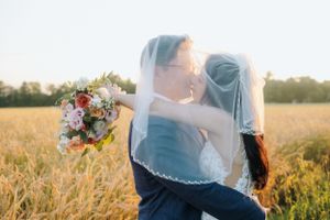 Romantic sunset wedding photos with flowing veil in golden light.
