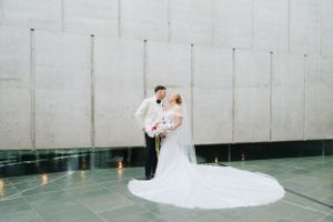 Modern minimalist wedding ceremony setup with white walls and reflective floor.