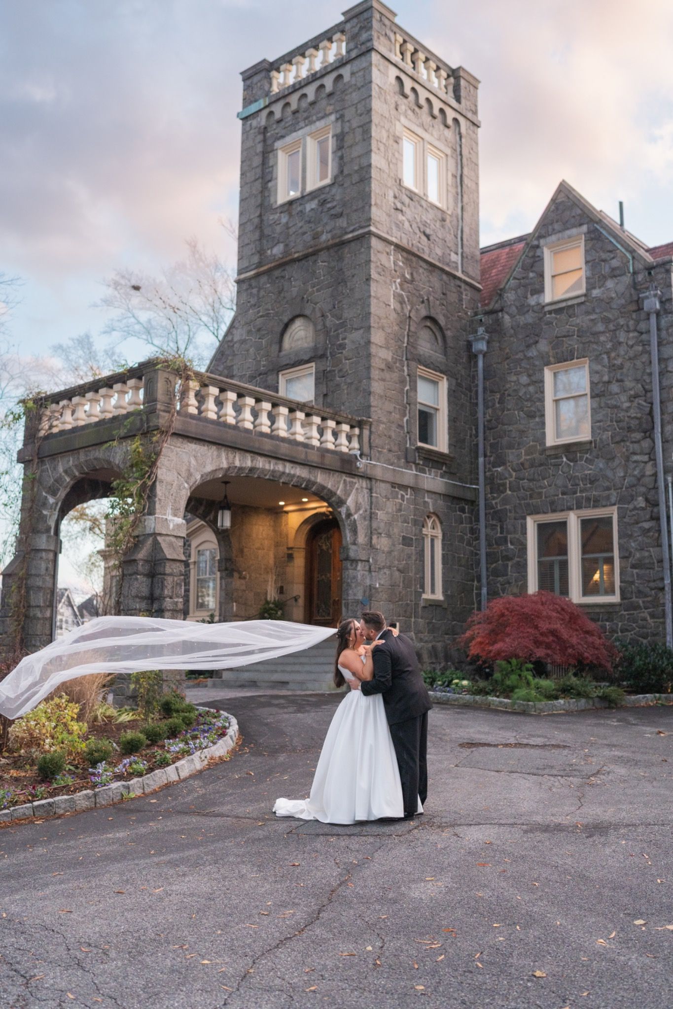 Delaware wedding photographer capturing romantic bride and groom portrait at historic stone venue with flowing veil.