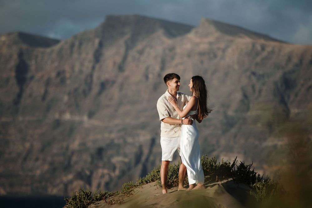 Romantic couple embracing on the hills with the Famara cliffs in the background - Lanzarote couple session