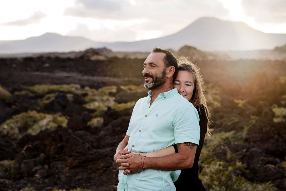 Happy couple embracing in the rugged volcanic fields at sunset - Lifestyle photography in Lanzarote by photoFuerte