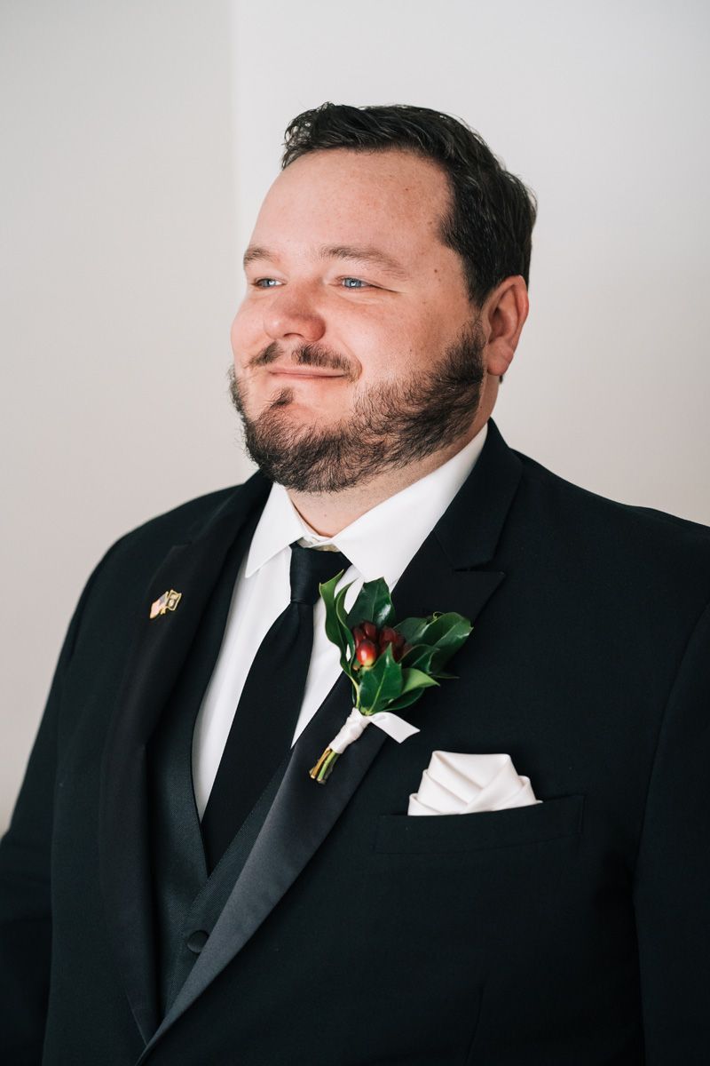 Portrait of winter groom in black suit.