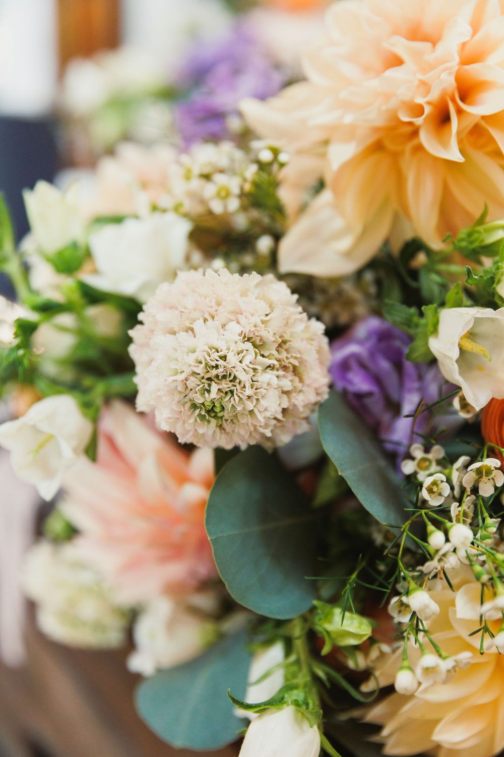 Beautiful bouquet arrangement featuring peach dahlias, white flowers, and eucalyptus leaves.