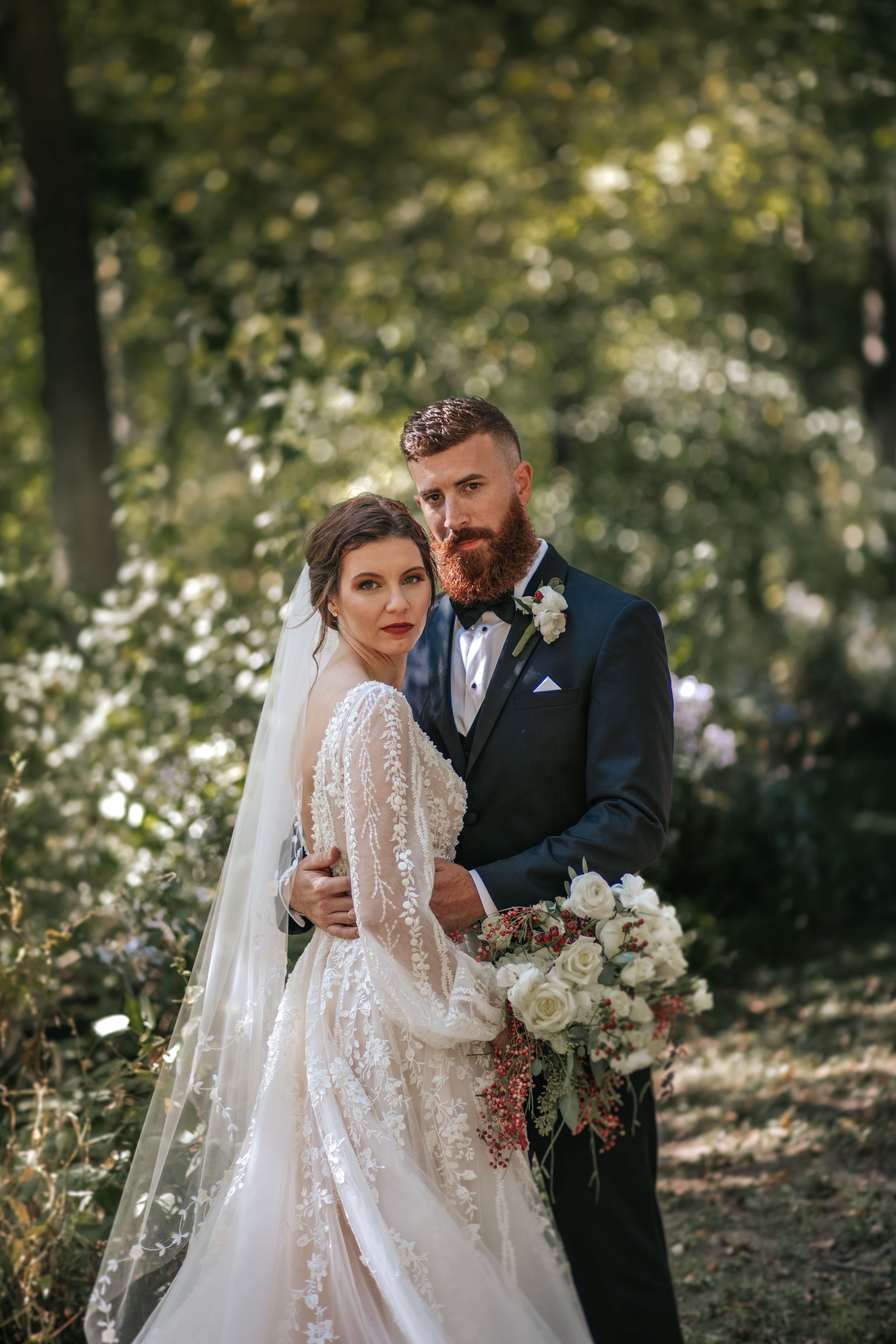 Ethereal wedding portraits in wooded setting with flowing lace dress and veil.
