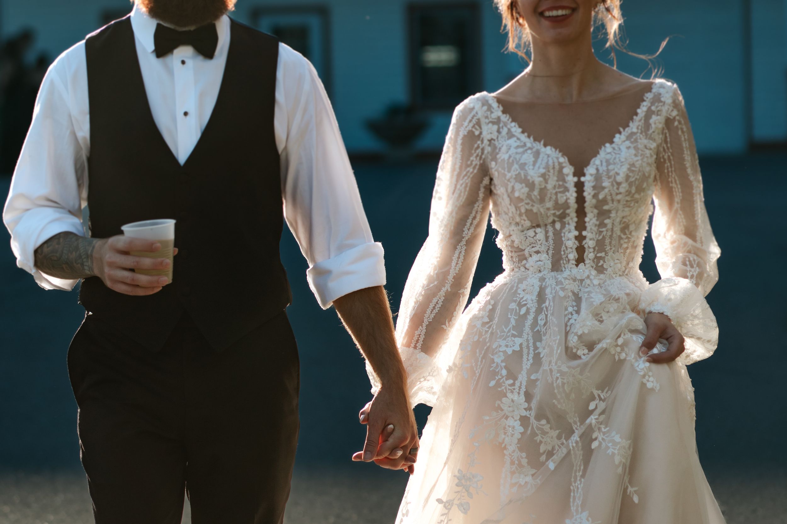 Elegant couple shares laughter during their wedding photoshoot with dramatic blue lighting.
