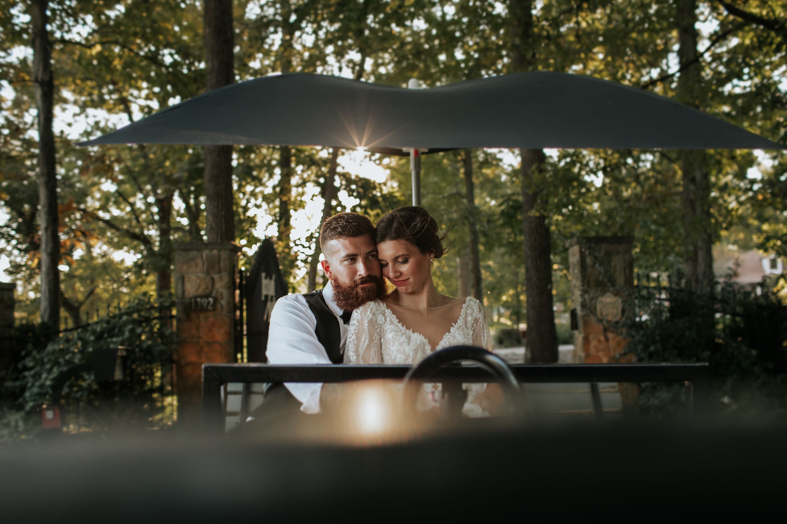 Romantic wedding portraits captured under tree canopy during golden hour.