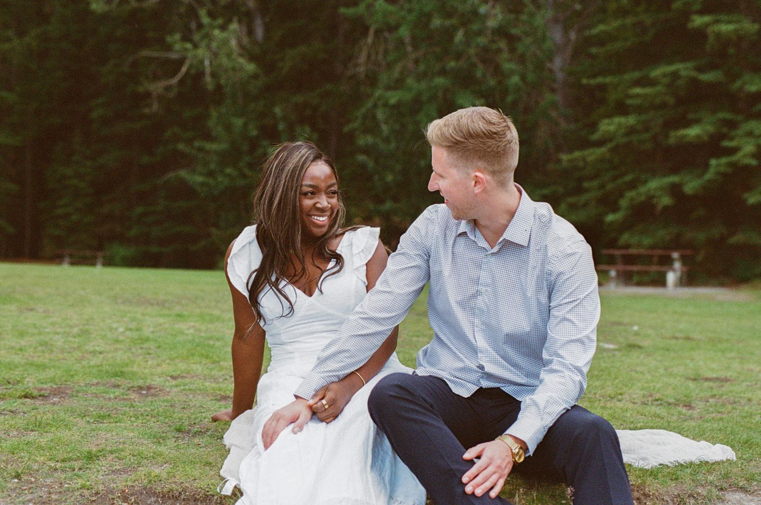 35 mm film photo of Bride laughing while groom holds her hand in a field in Banff