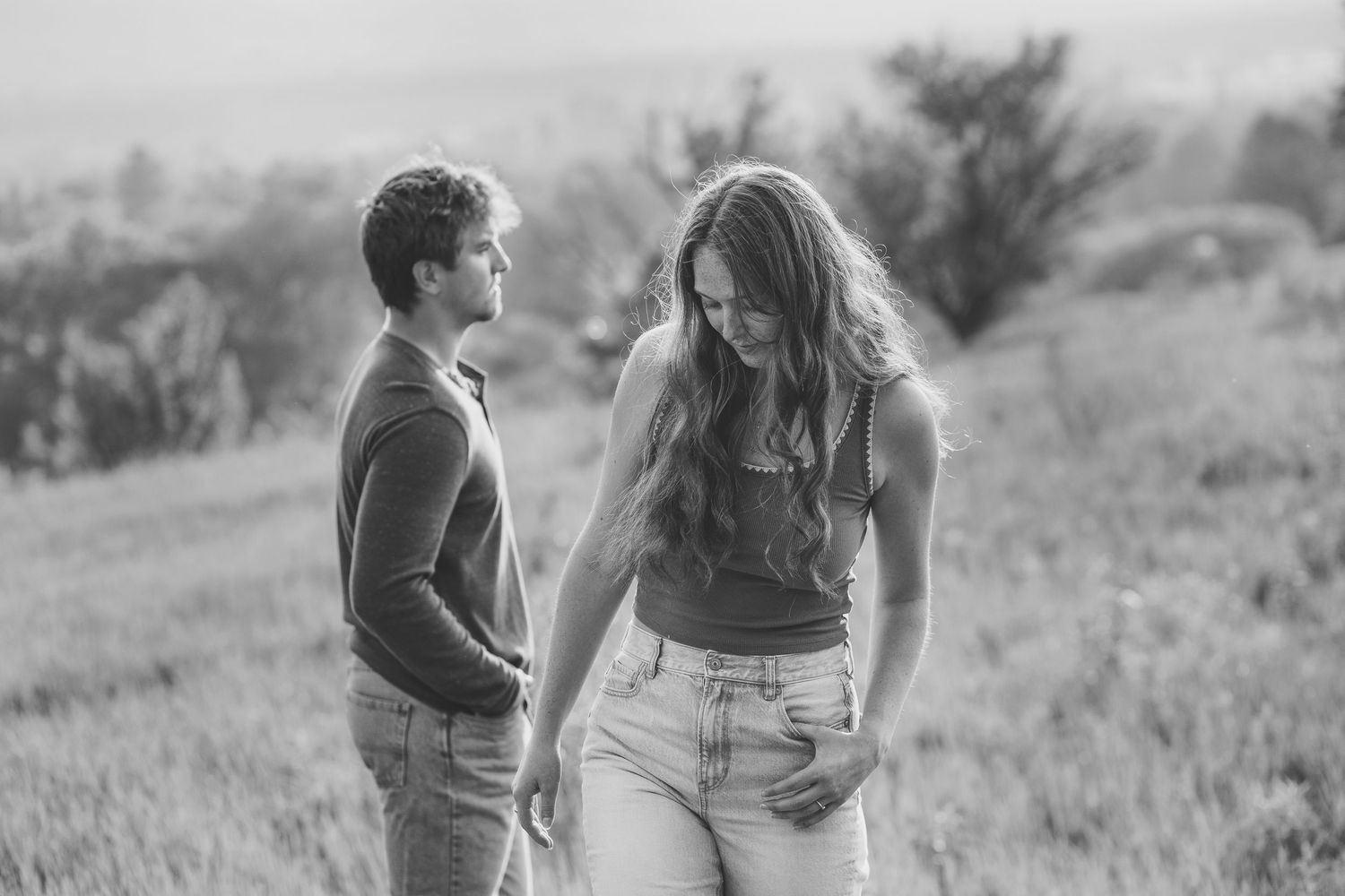 Candid black and white photo of people in a grassy field.