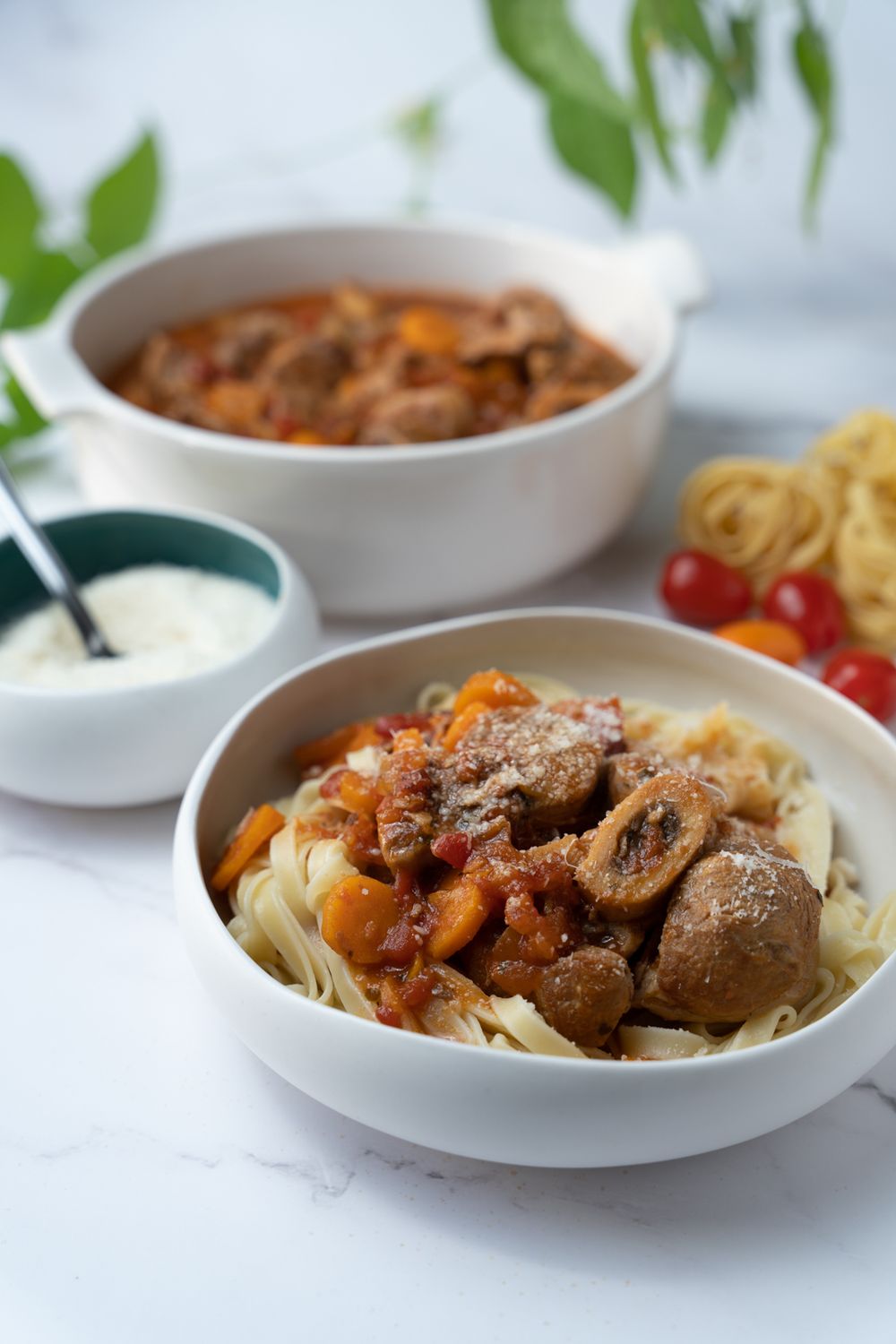 Homemade beef stroganoff with mushrooms and egg noodles served on white plates in a progression of plated dishes.