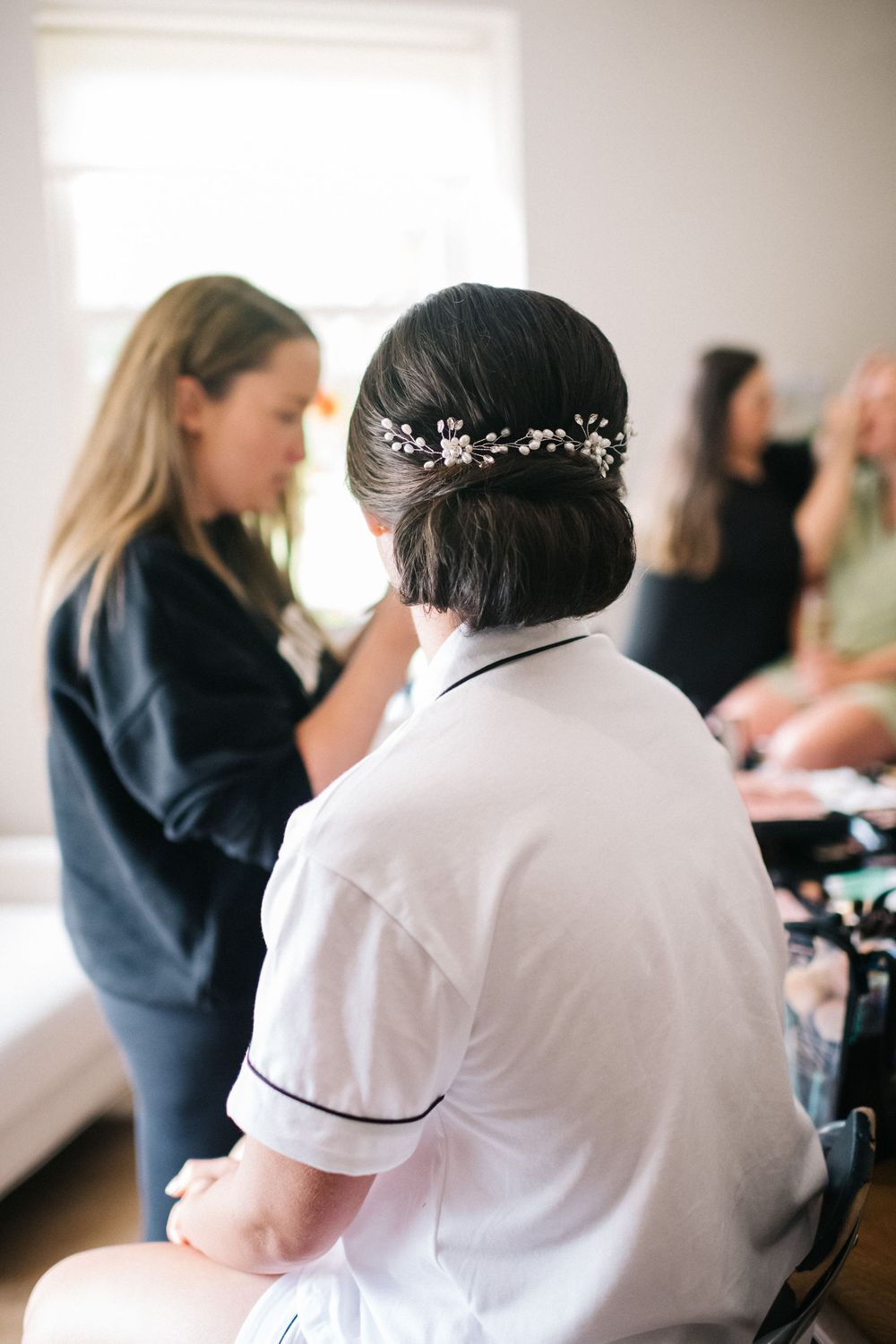Wedding preparation scene showing someone getting ready with a delicate hair accessory.