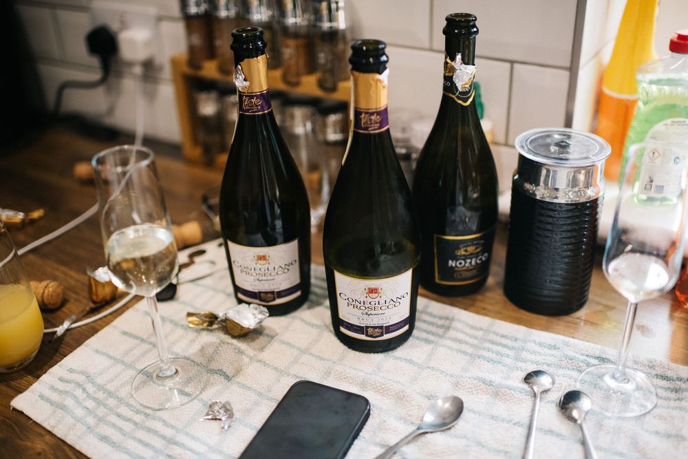 Collection of champagne bottles and glasses arranged on a white tablecloth.
