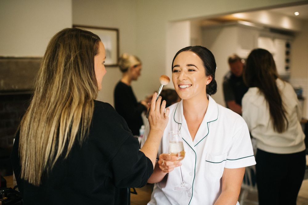 Wedding party getting ready with champagne and laughter in a bridal suite.