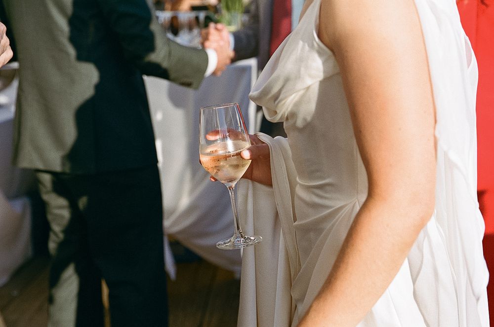 Wedding guests raise champagne glasses during a celebratory toast at an elegant reception.