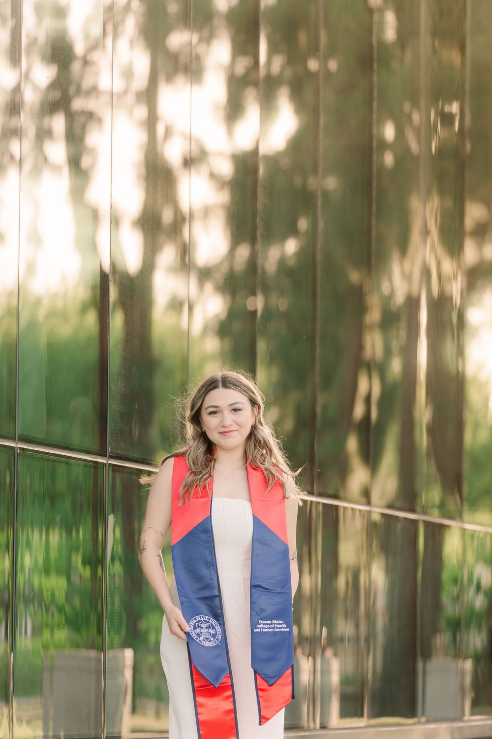 A person wearing a red and blue life vest stands in a forest with blurred trees in the background.