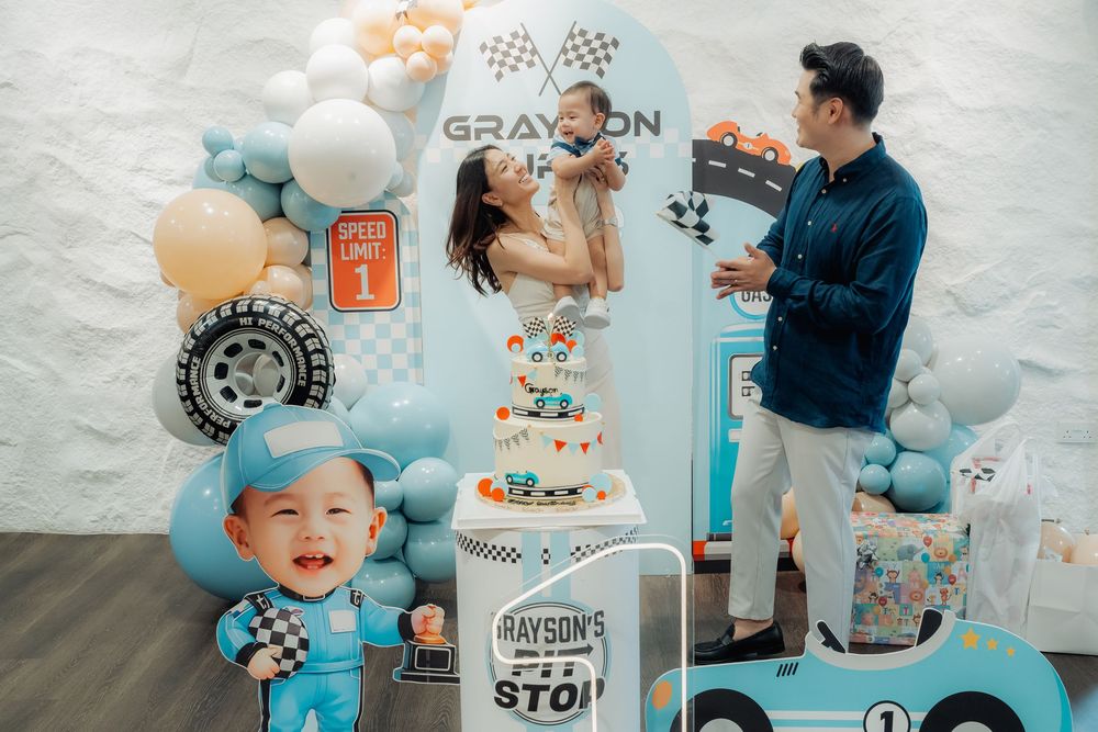 Car racing themed birthday party setup with custom signage and festive decorations.