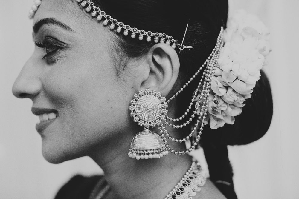 Side profile showcasing ornate traditional Indian bridal jewelry and hair accessories in black and white.
