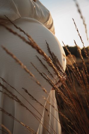 Zwangerschap fotosessie bij zonsondergang golden hour in Eindhoven door fotograaf uit Noord-Brabant met warme tinten.