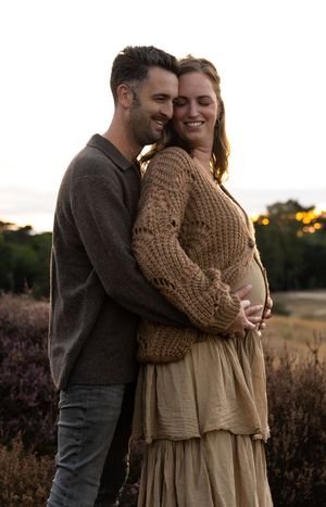 Warme zwangerschapsshoot in de herfst met vallende bladeren, vastgelegd door zwangerschapsfotograaf in Eindhoven, Noord-Brabant.