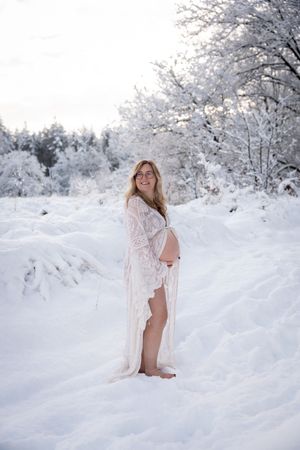 Intieme zwangerschapsshoot in een besneeuwd landschap, professioneel vastgelegd door zwangerschapsfotograaf in Eindhoven, Noord-Brabant.