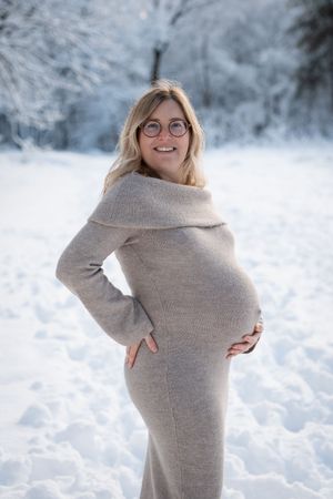 Sfeervolle zwangerschapsshoot in de sneeuw met warme styling, professioneel gefotografeerd door zwangerschapsfotograaf in Eindhoven.