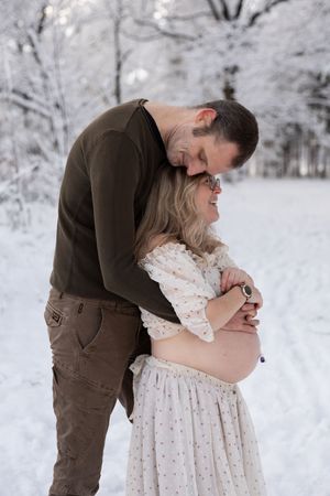 Winterse zwangerschapsshoot in de sneeuw, vastgelegd door ervaren zwangerschapsfotograaf in Eindhoven, Noord-Brabant, met zachte en pure uit