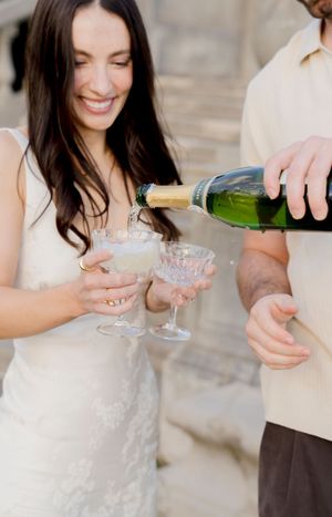 Hands holding champagne glasses in an elegant setting during a celebration toast.