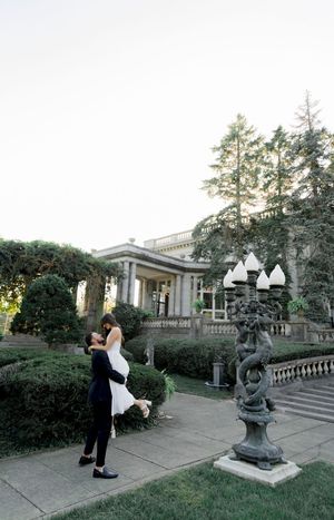 A scenic garden terrace with stone balustrades and sculptures creates an elegant outdoor setting.