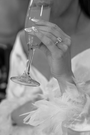 Close-up view of champagne glasses clinking in celebration with soft white fabric in the background.