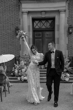 A sequence of playful dancing moments captured in black and white on a brick building's lawn.