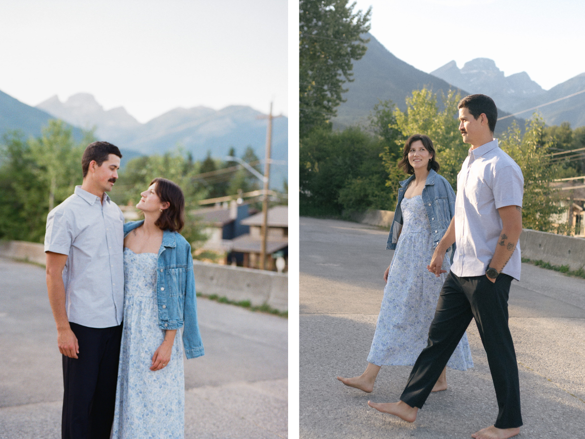 man and woman walk up the street with the three sisters mountain in Fernie rising behind them