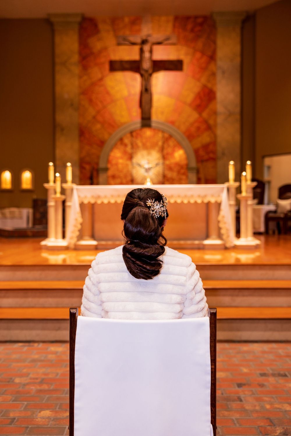A series of four connected images showing a person in white seated in a church with candles and crosses in the background.
