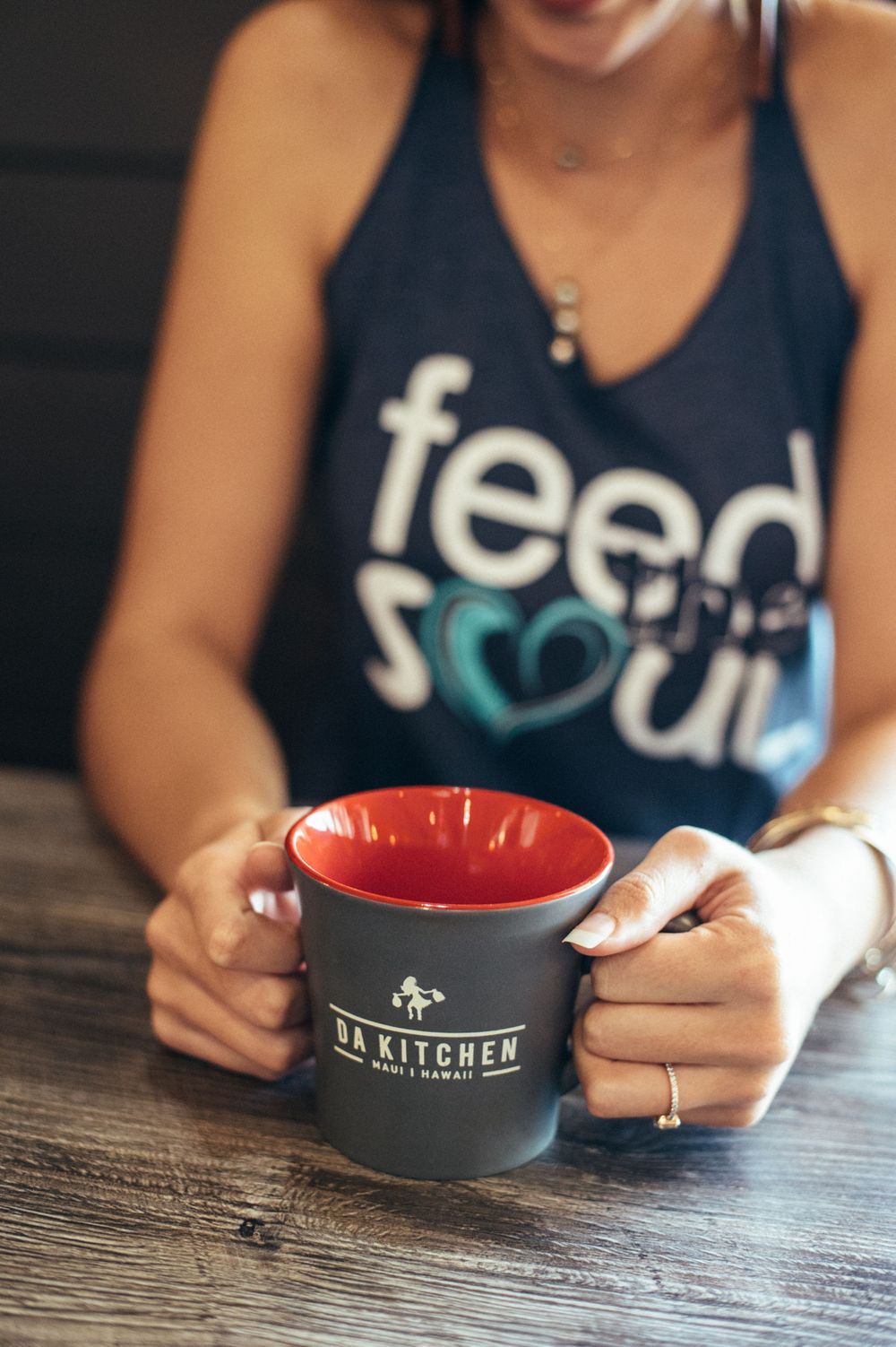 Hands holding branded restaurant bowls with Da Kitchen logo.