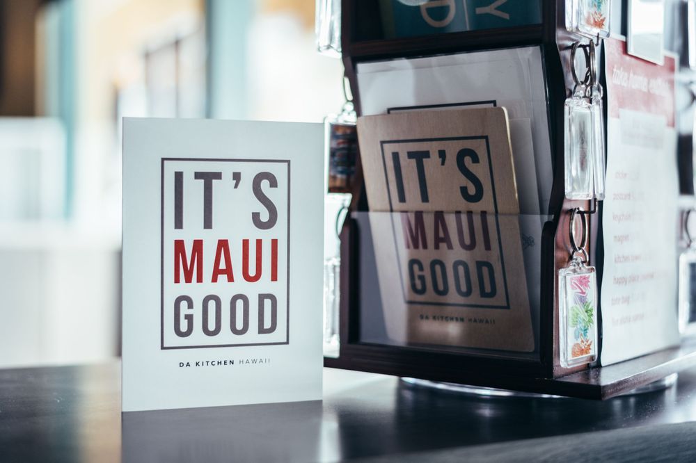 Two 'It's Maui Good' retail signs displayed in store setting.