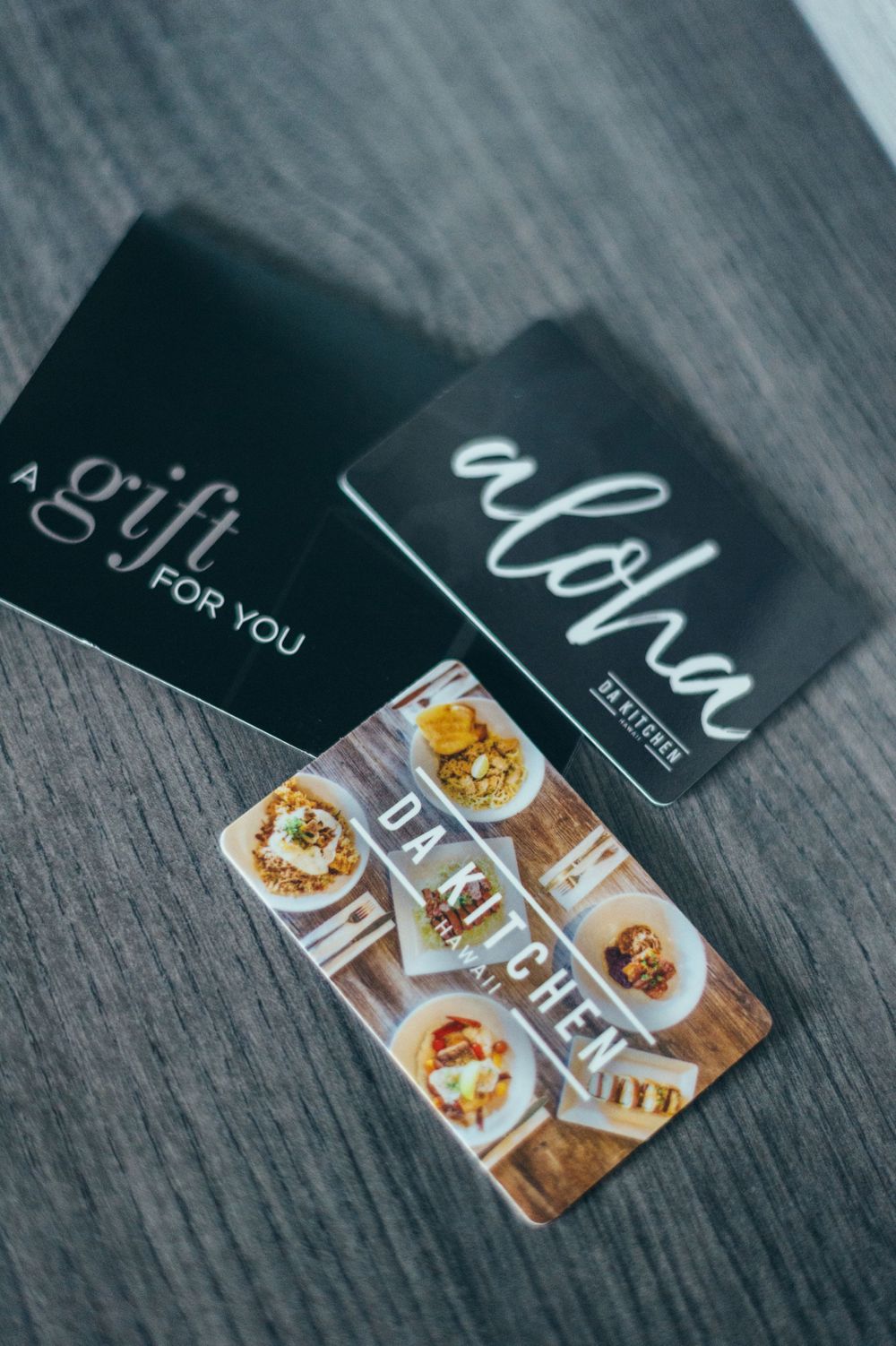 Gift cards and promotional materials displayed on dark wooden surface.