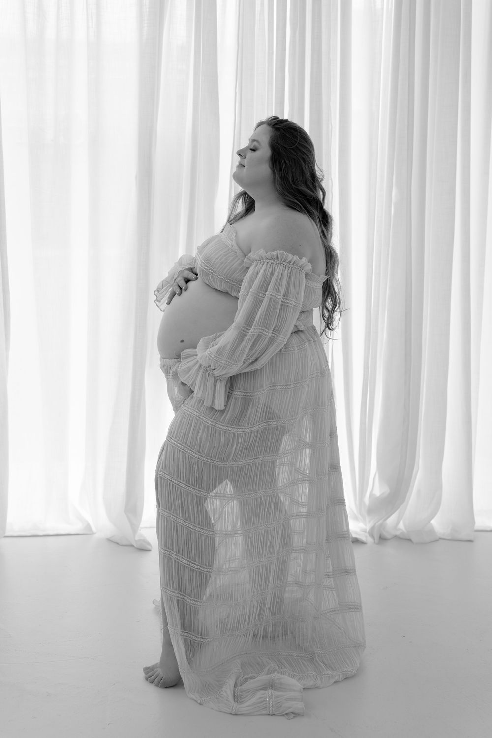 Artistic black and white portraits of a figure in flowing white fabric against bright curtains.