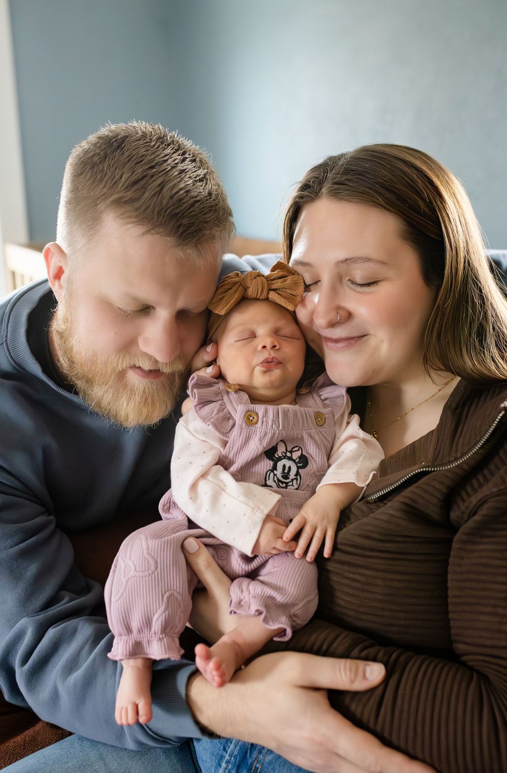 A loving family moment captured in a series of tender embraces and cuddles on a couch.